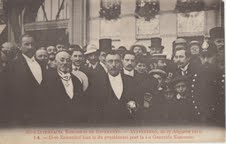 el 1911, venas el serio de fotaj poŝtkartoj, kiuj dokumentis okazintaĵojn de la 7-a UK en Antverpeno. Ĝi montras Zamenhof kaj d-ron van der Biest-Andelhof, prezidanto de la kongreso, apud antverpena policisto.